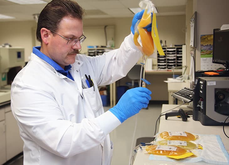Lab technician with a unit of platelets.